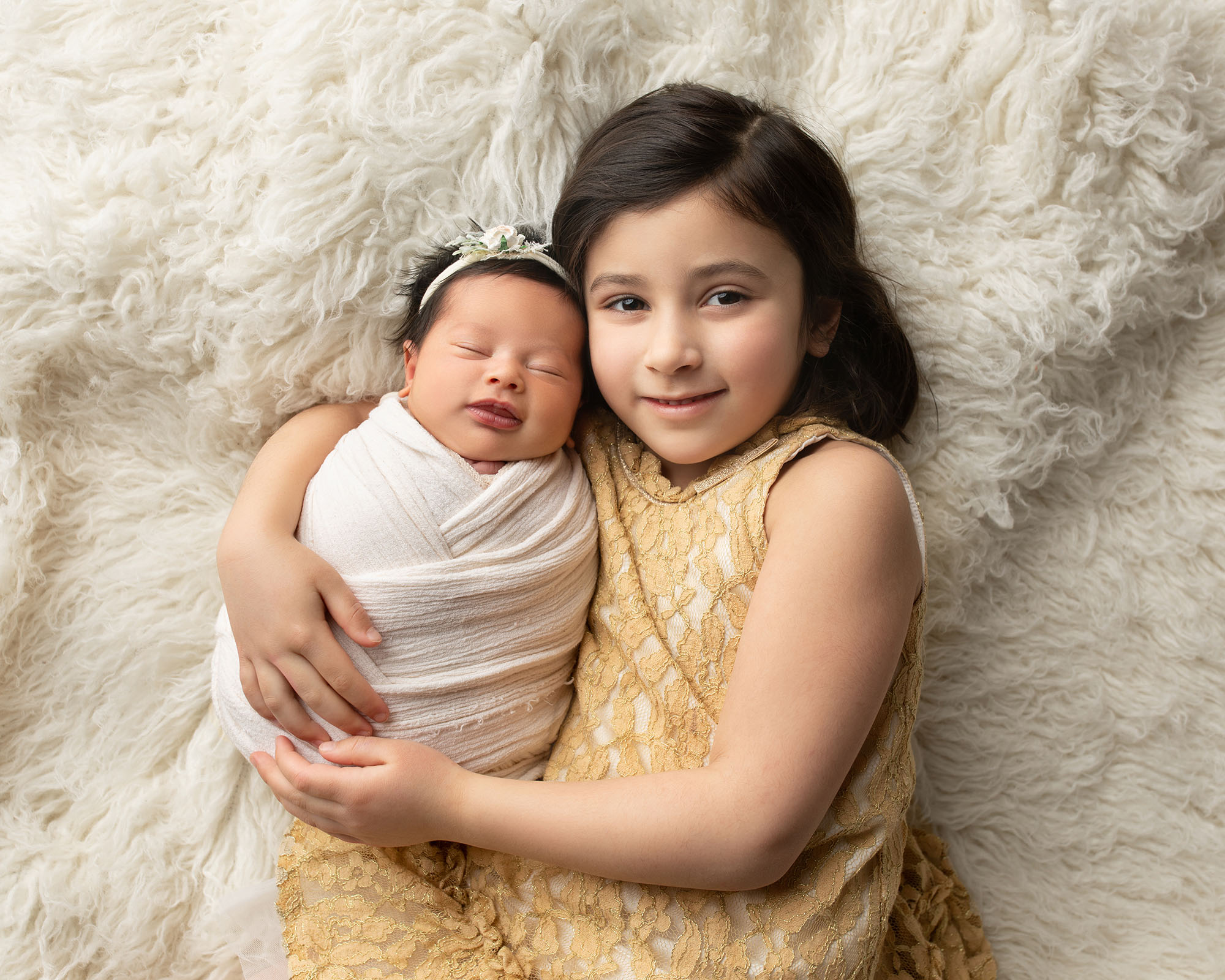 Newborn baby and sister posing together 